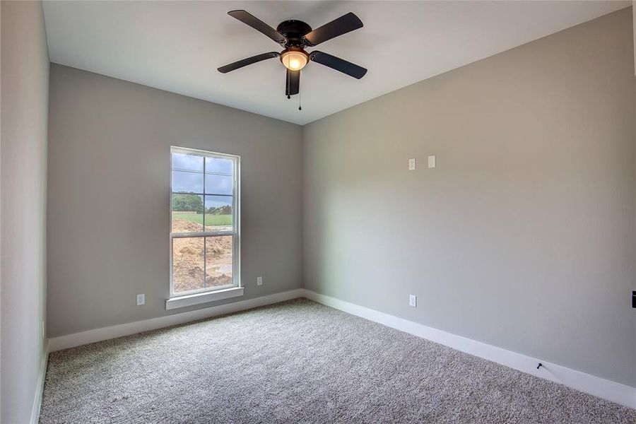 Unfurnished room featuring carpet flooring and ceiling fan