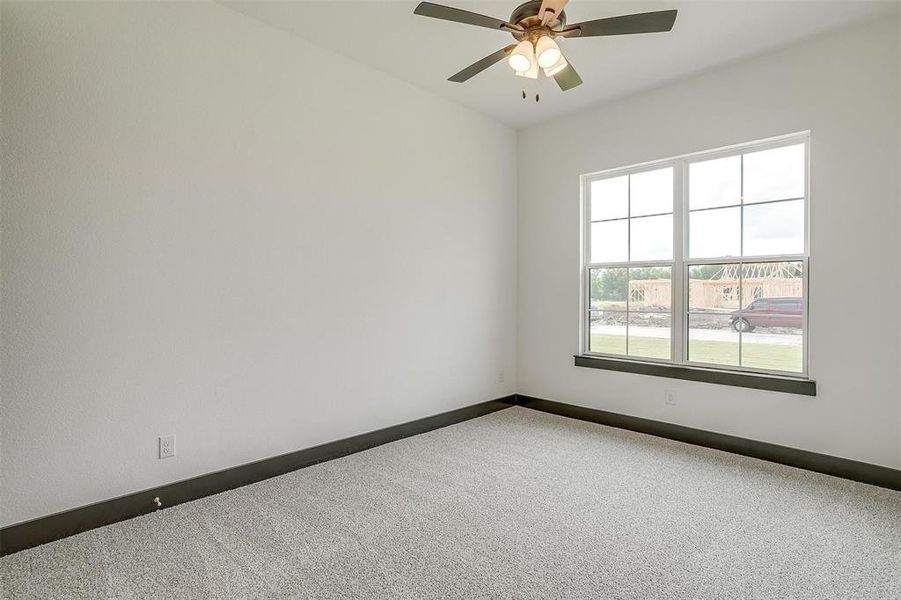 Carpeted spare room featuring ceiling fan