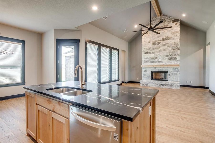 Kitchen with vaulted ceiling with beams, dishwasher, a kitchen island with sink, and a wealth of natural light