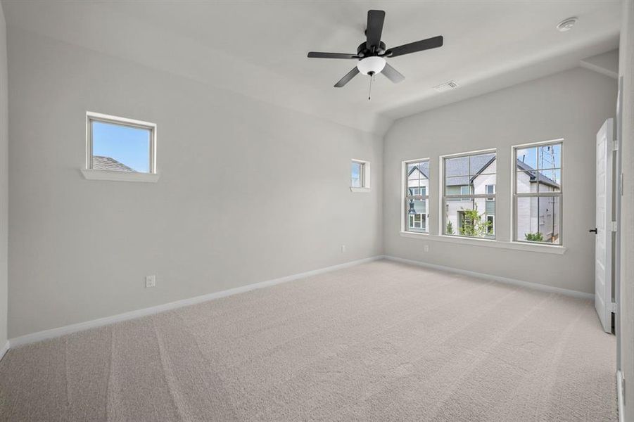 Spare room with light carpet, ceiling fan, and vaulted ceiling