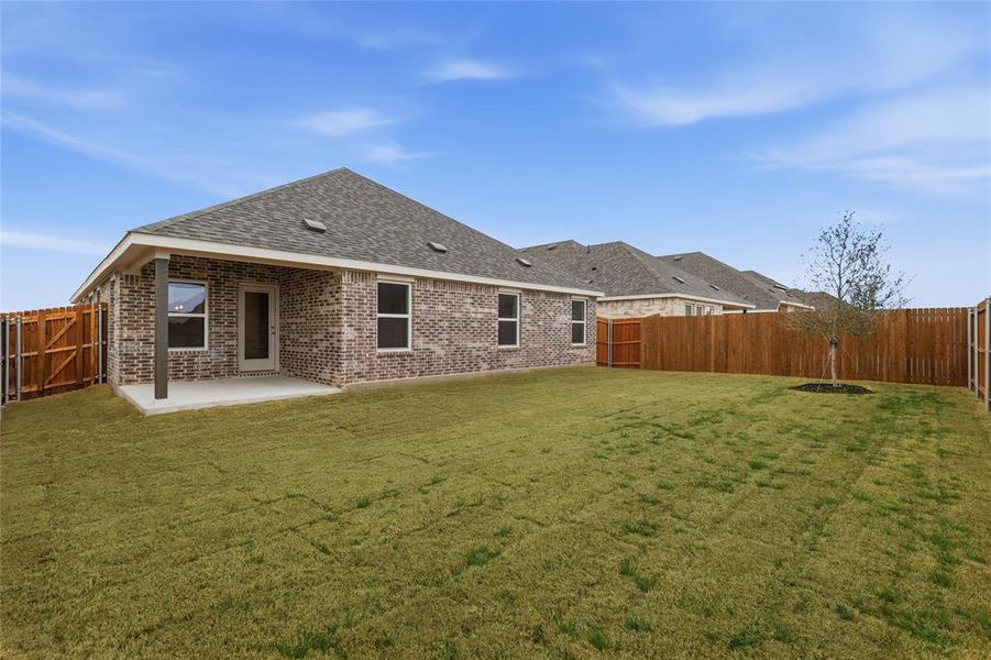 Rear view of house featuring brick siding and a fenced backyard