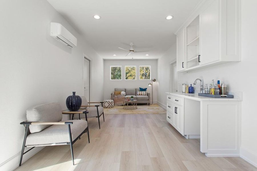 Sitting room featuring recessed lighting, light wood finished floors, a ceiling fan, and a wall unit AC