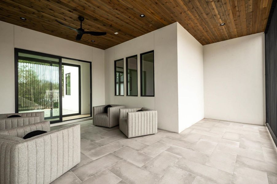 View of front covered patio with ceiling fan, steel frame gives good amount of privacy from front view