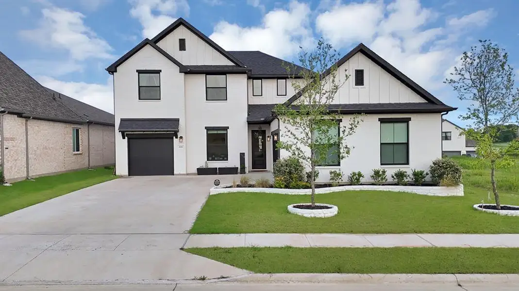 Contemporary two-story residence featuring a white brick exterior with black trim accents Contemporary two-story residence featuring a white brick exterior with black trim accents
