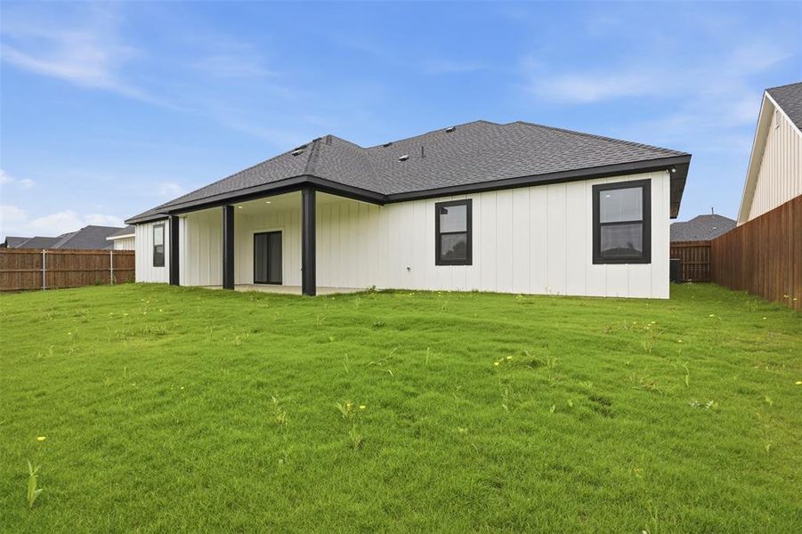 Expansive green lawn with a privacy fence surrounding the property