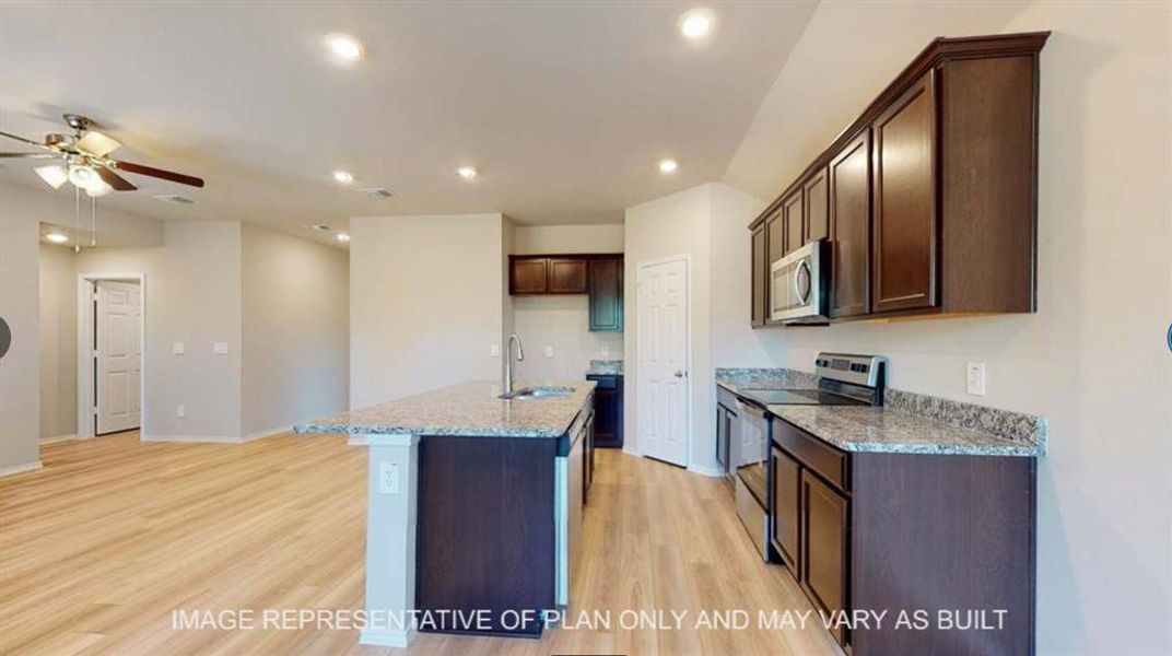 Kitchen featuring stainless steel appliances, dark wood finish cabinets, ceiling fan, light wood-type flooring, and recessed lighting