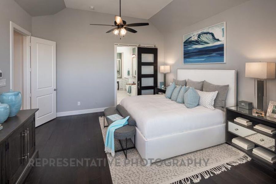 Bedroom with lofted ceiling, wood finished floors, ensuite bath, and a ceiling fan Bedroom with lofted ceiling, wood finished floors, ensuite bath, and a ceiling fan