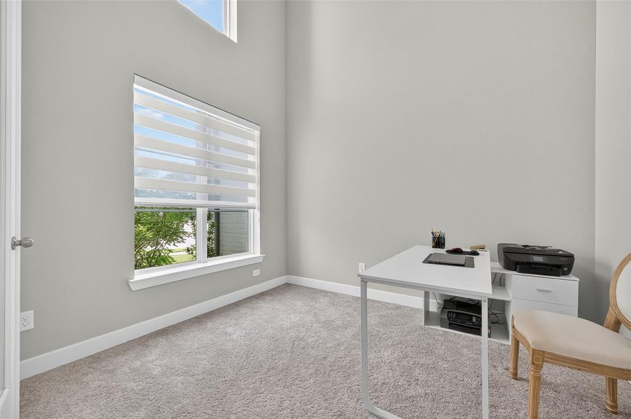 This private workspace features tall windows, modern dual-shade blinds, and an open layout ideal for focus or creativity. A peaceful retreat to work from home or manage daily tasks in comfort.