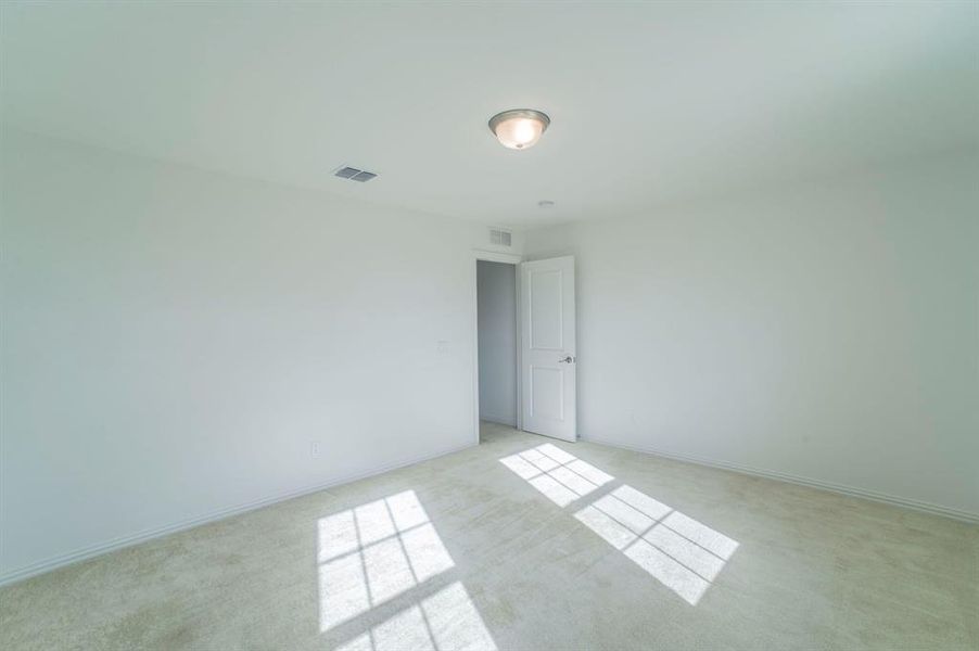 Spare room with light carpet and baseboards Spare room with light carpet and baseboards