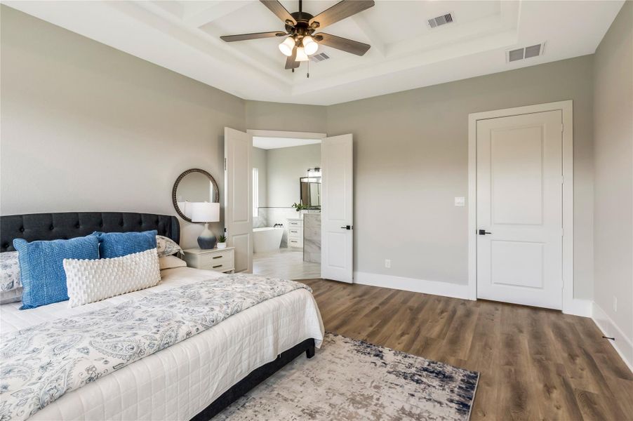Luxurious primary bedroom with direct access to an elegant bathroom.