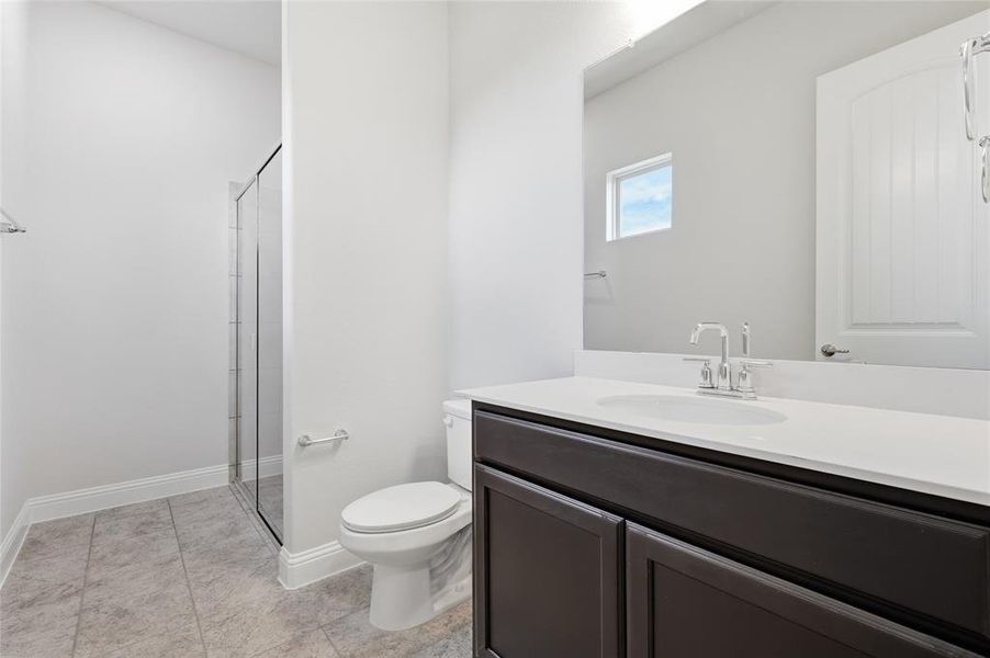 Bathroom with vanity, a shower stall, and light tile patterned floors Bathroom with vanity, a shower stall, and light tile patterned floors