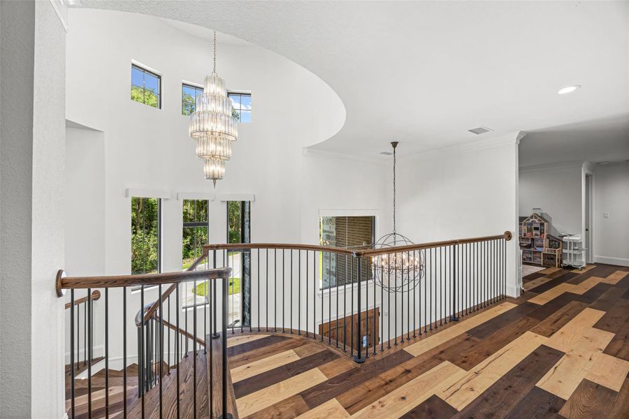 Second-floor landing highlighted by elegant, high-end chandeliers that enhance the home’s upscale lighting design. Second-floor landing highlighted by elegant, high-end chandeliers that enhance the home’s upscale lighting design.