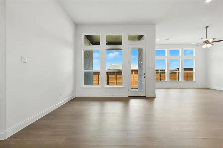Spare room with plenty of natural light, wood finished floors, and ceiling fan