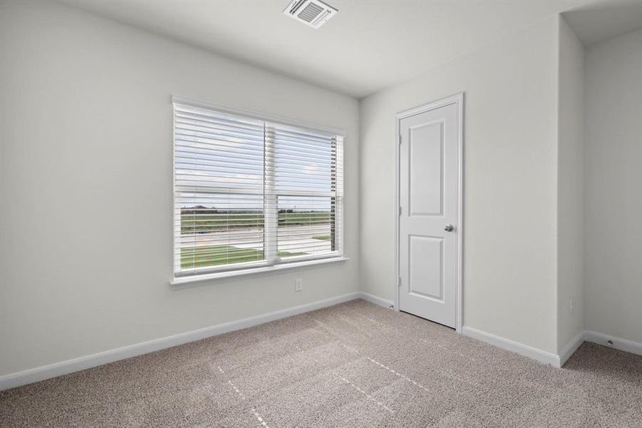 Unfurnished bedroom with light colored carpet and baseboards