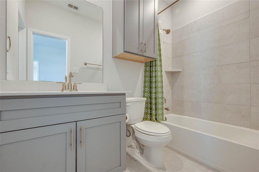 3rd full bath attached to 3rd bedroom features quartz counters and gold fixtures.