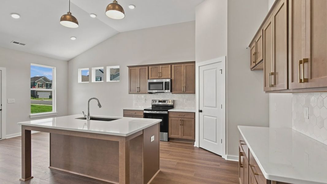 Kitchen with ceramic tile backsplash, quartz countertops, and stainless steel appliances Kitchen with ceramic tile backsplash, quartz countertops, and stainless steel appliances