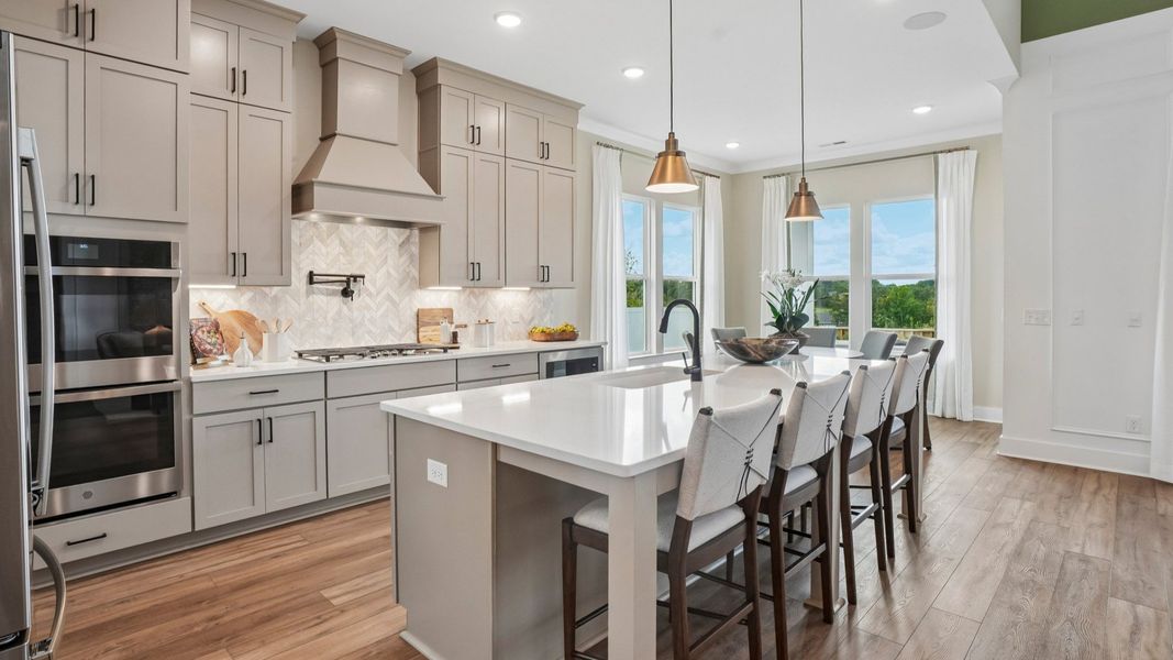 View of kitchen with quartz countertops, tile backsplash, and pendant lighting View of kitchen with quartz countertops, tile backsplash, and pendant lighting