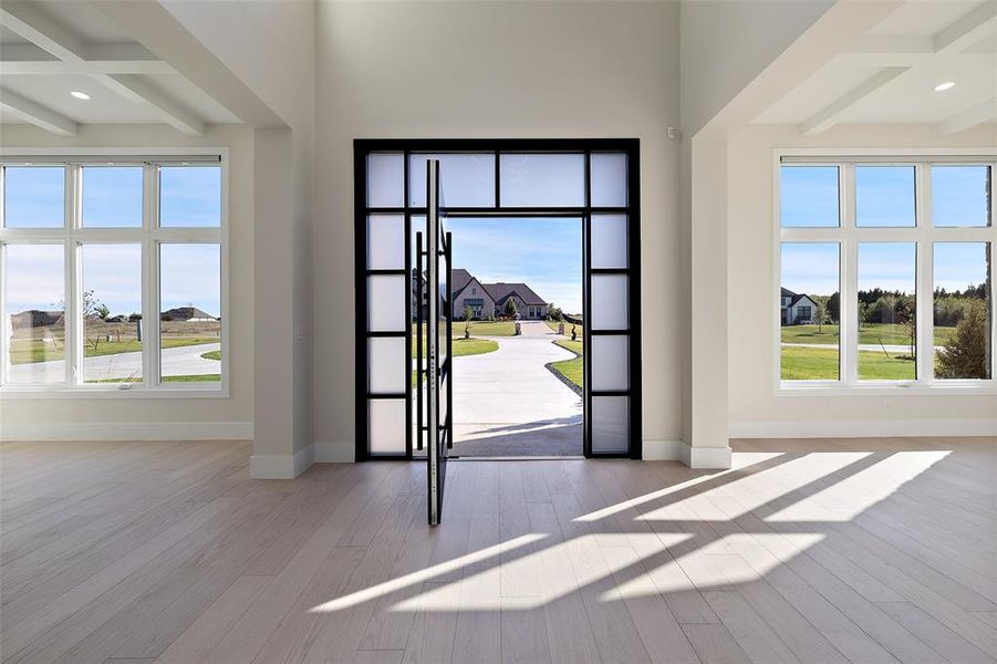 Foyer featuring plenty of natural light, beamed ceiling, coffered ceiling, and light wood-type flooring