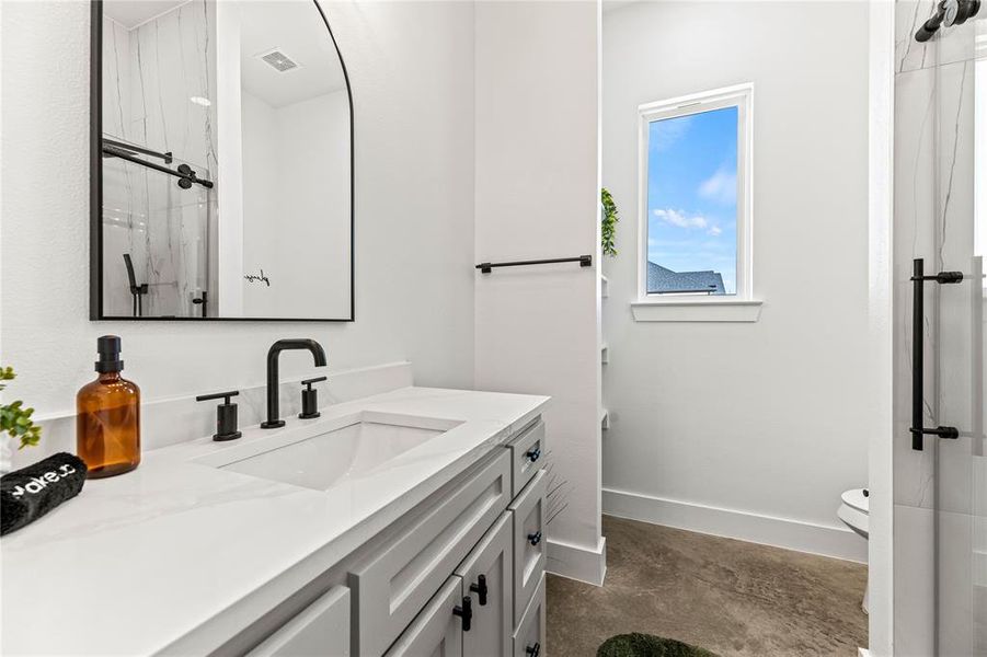 Full bathroom featuring vanity, concrete flooring, and a shower Full bathroom featuring vanity, concrete flooring, and a shower