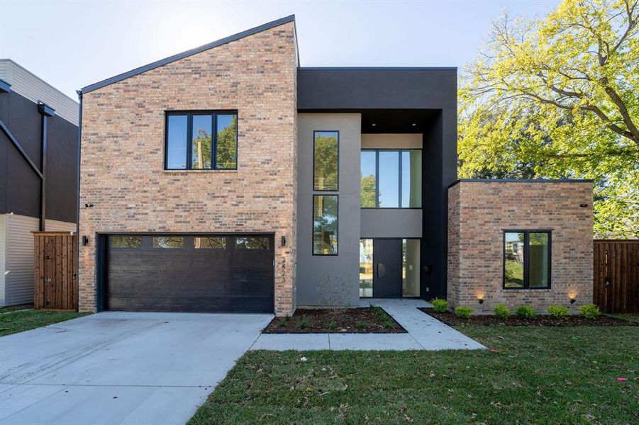 Modern home featuring a front lawn and a garage