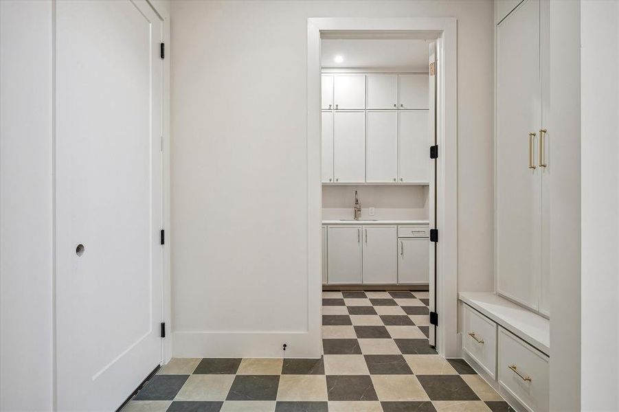 Mud room, checkered tile floor, built-in cabinetry, access to laundry Mud room, checkered tile floor, built-in cabinetry, access to laundry