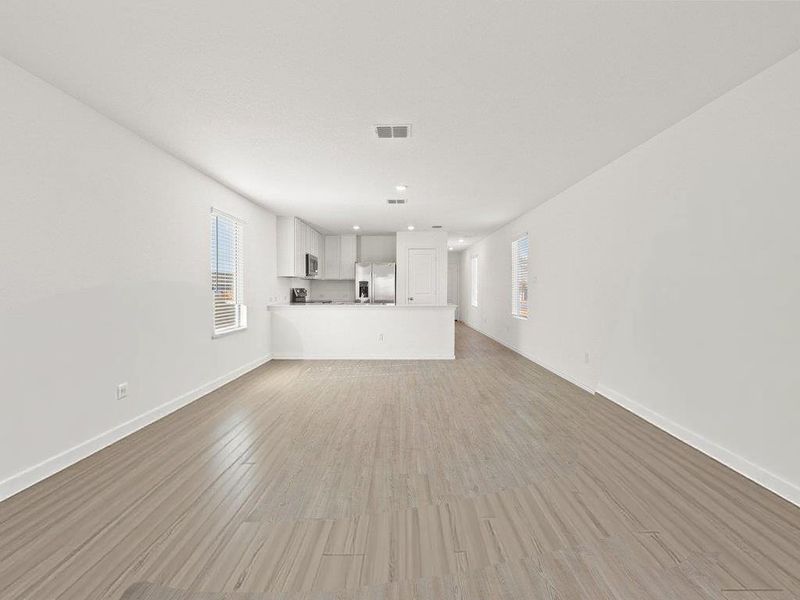 Photo has been enhanced with virtual modification.  Unfurnished living room featuring light wood finished floors and recessed lighting