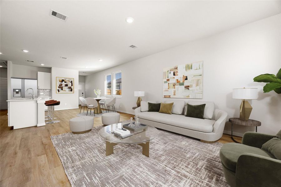 An open-concept layout with luxury vinyl plank flooring and neutral finishes creates a modern, cohesive space. Large windows invite abundant natural light, highlighting the home’s clean design.