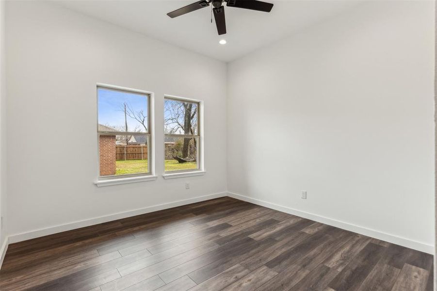 Unfurnished room with dark wood-type flooring and ceiling fan