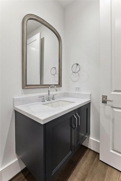 Hallway powder room accented with an elegant framed mirror.