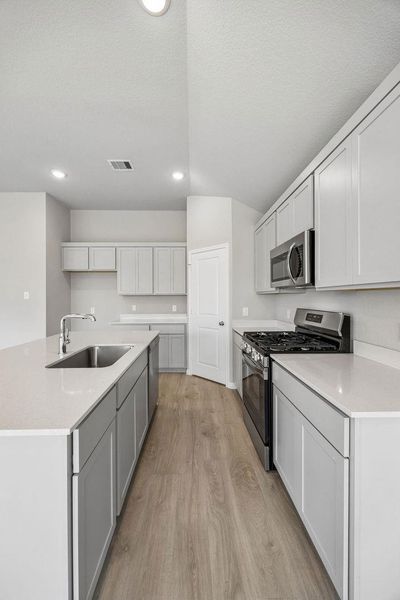 Culinary adventures await in this kitchen featuring abundant cabinetry and a spacious island.