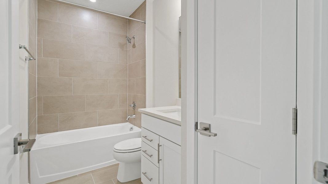 Guest bathroom in The Atlantic by DRB Homes with tiled shower-tub combo, modern fixtures, and linen closet. Guest bathroom in The Atlantic by DRB Homes with tiled shower-tub combo, modern fixtures, and linen closet.