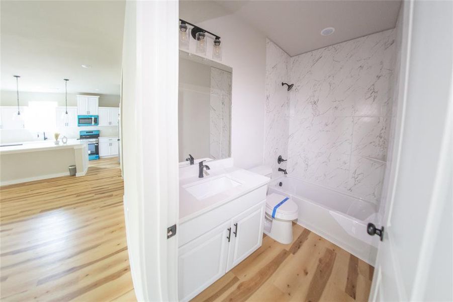 Full bathroom with vanity, shower / washtub combination, and light wood-style flooring