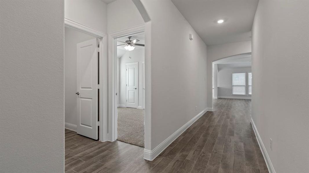 Hallway with arched walkways and wood tiled floors