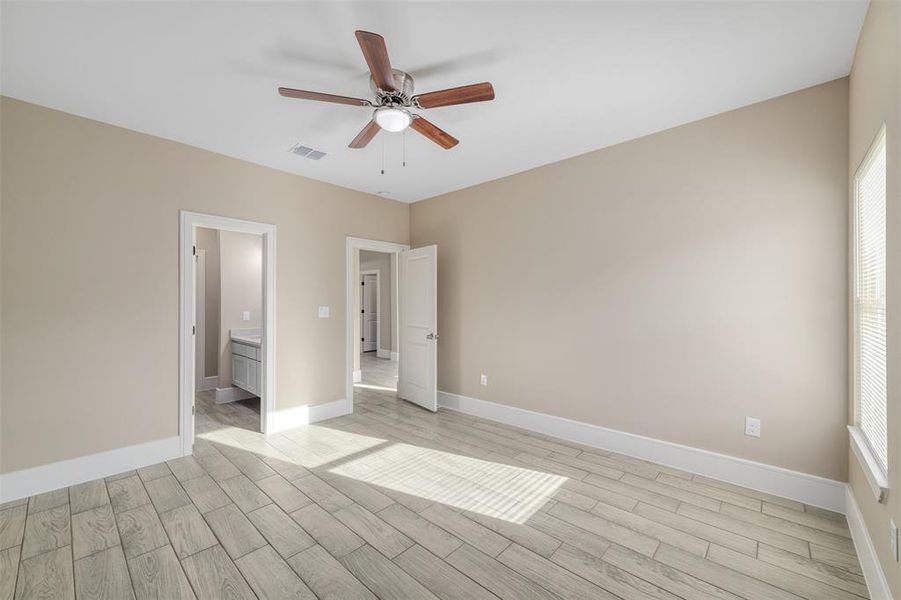 Empty room with ceiling fan and light hardwood / wood-style floors