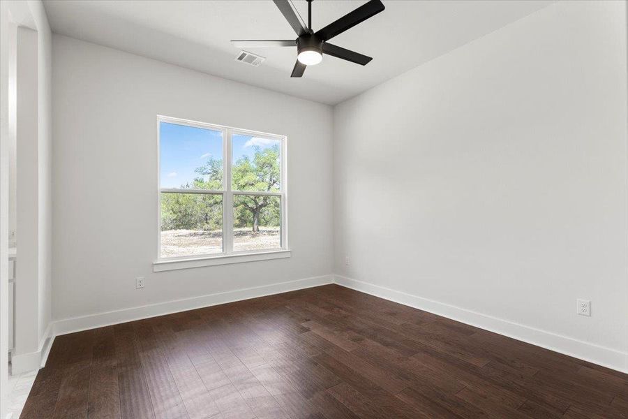 Spare room with dark wood-style floors, a ceiling fan, and baseboards Spare room with dark wood-style floors, a ceiling fan, and baseboards