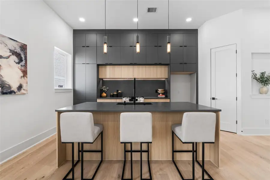 Symmetry meets sophistication in this stunning culinary centerpiece. The waterfall island serves as both functional workspace and refined gathering point, flanked by a wall of custom cabinetry that reads like art. Every element—from the minimalist pendant lighting to the integrated appliance space—is a nod to intentional design, where form follows function, and everyday moments feel beautifully elevated. Symmetry meets sophistication in this stunning culinary centerpiece. The waterfall island serves as both functional workspace and refined gathering point, flanked by a wall of custom cabinetry that reads like art. Every element—from the minimalist pendant lighting to the integrated appliance space—is a nod to intentional design, where form follows function, and everyday moments feel beautifully elevated.