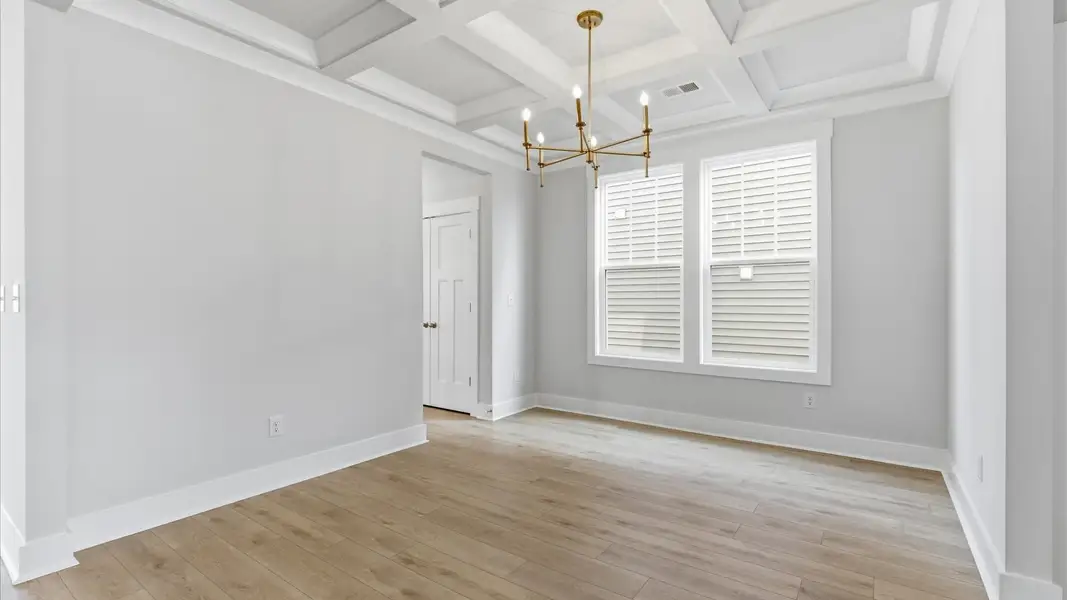 Accomplished dining room featuring coffered ceiling and stylish lighting for a timeless look at Foxbank in Gray Court, SC