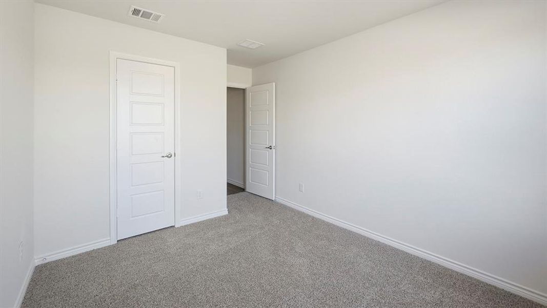 Unfurnished bedroom with carpet flooring and baseboards Unfurnished bedroom with carpet flooring and baseboards