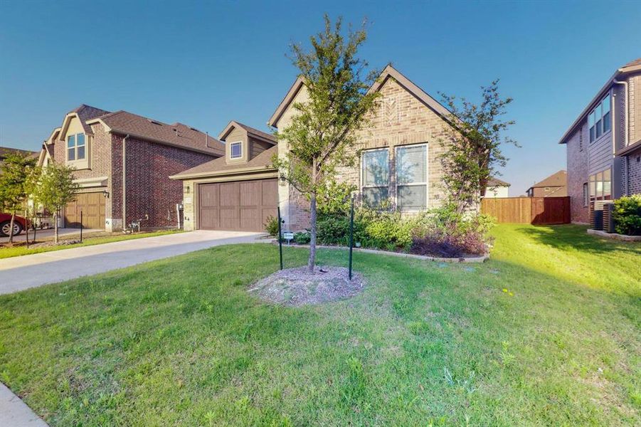 Traditional home featuring driveway, an attached garage, and brick siding