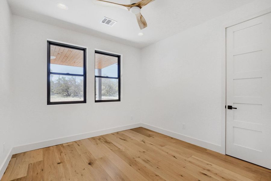 Unfurnished room with light wood finished floors and a ceiling fan Unfurnished room with light wood finished floors and a ceiling fan