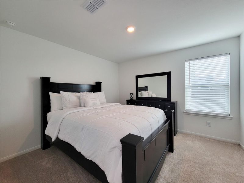 Cozy bedroom featuring. Natural light fills the room through a window with blinds, creating a bright and inviting atmosphere.