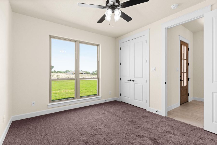 Unfurnished bedroom featuring light carpet, a ceiling fan, and a closet Unfurnished bedroom featuring light carpet, a ceiling fan, and a closet