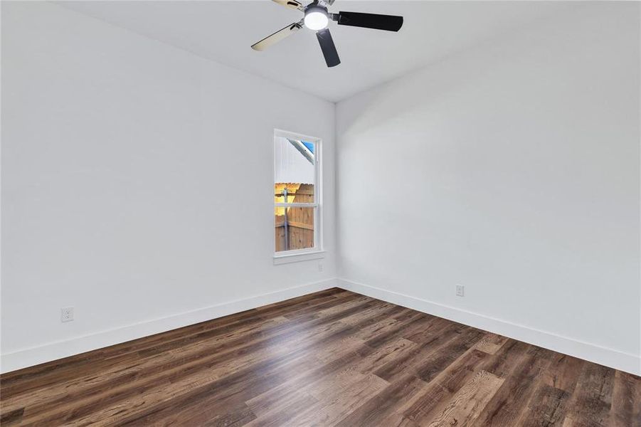 Spare room with dark wood-style floors and a ceiling fan