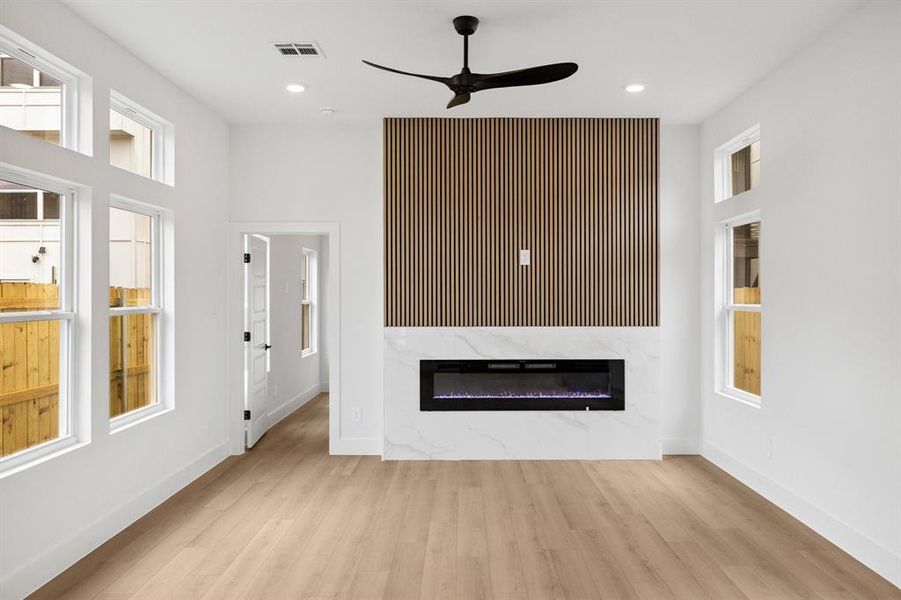 Unfurnished living room with ceiling fan, a fireplace, wood finished floors, and recessed lighting