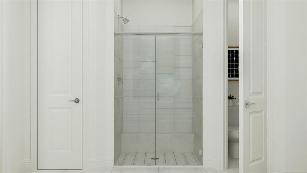 Bathroom with toilet, tile patterned flooring, and a shower with door