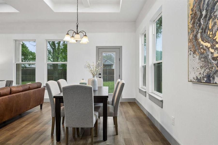Dining area featuring a contemporary chandelier and a trayed ceiling