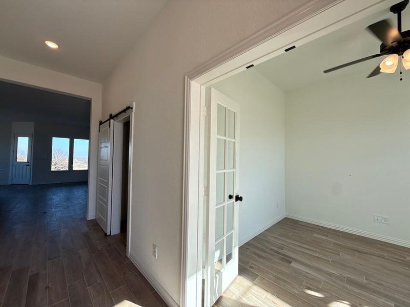 Hall with a barn door and wood finish floors