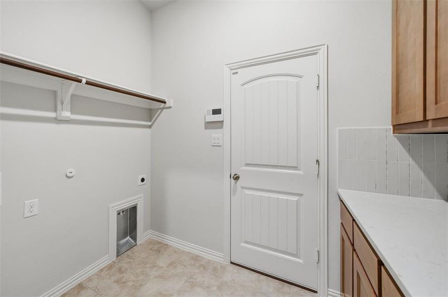 Laundry area featuring hookup for an electric dryer and hookup for a gas dryer Laundry area featuring hookup for an electric dryer and hookup for a gas dryer