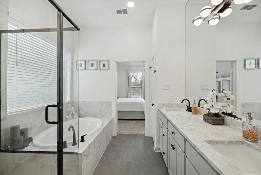 THIS BATHROOM VIEW HIGHLIGHTS THE SEPARATE SOAKING TUB WITH TILE SURROUND AND THE GLASS-ENCLOSED SHOWER.