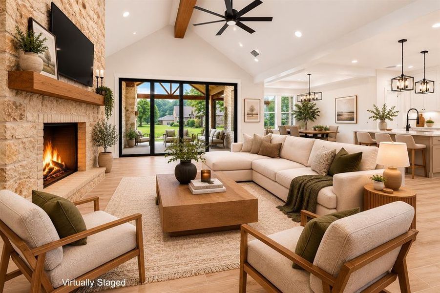 Vaulted ceiling living area featuring a stone fireplace, wood-finish flooring, and a ceiling fan Vaulted ceiling living area featuring a stone fireplace, wood-finish flooring, and a ceiling fan